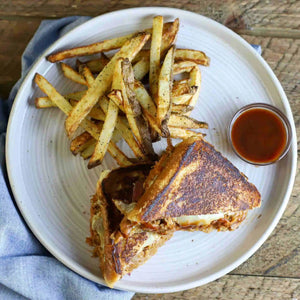 a plate of peach whiskey brie pulled pork sandwich and fries